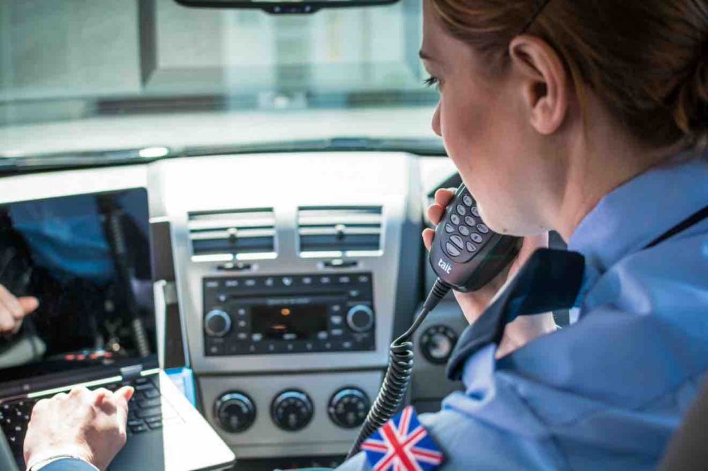 Police officer making a call on a Tait TM8 mobile radio