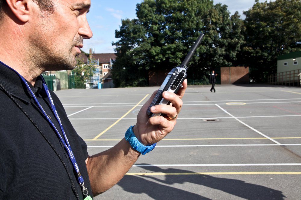 Hytera PD685 DMR walkie talkie in use at a school playground